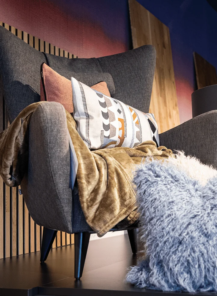 Präsentation verschiedener Wohntextilien auf Polstersessel